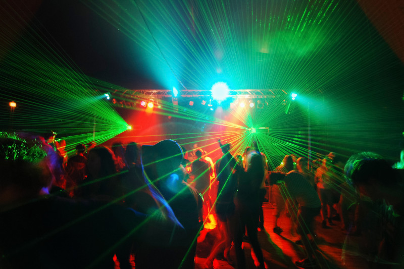 crowd dancing on a club dance floor with green lasers